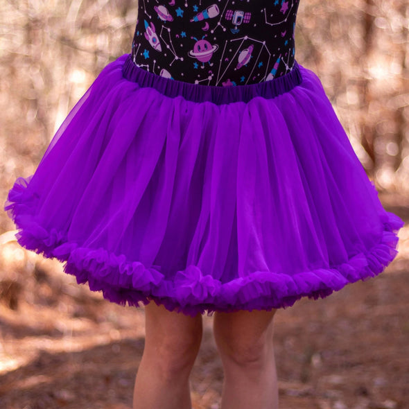 Model wearing Reach for the Stars Onesie and Amethyst Tutu. Tutu fits from hips to a few inches above the knee and has a super stretchy, elastic waistband. 